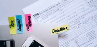 Taxes for Digital Nomads in Asia: The 2025 Compliance Guide A US tax return form with sticky notes reading Tax, Annual and Deadline beside a phone calculator