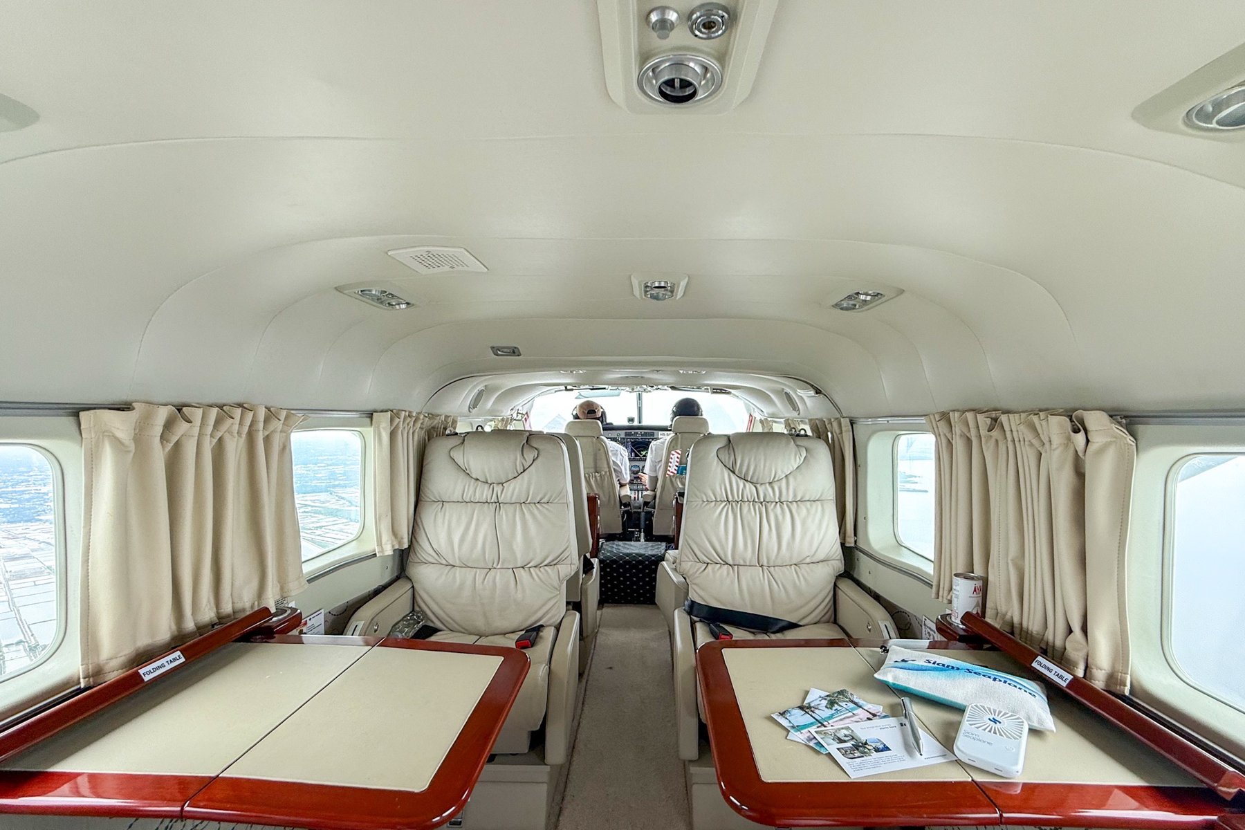 Inside the cabin, with folding tables and a clear view through to the pilots