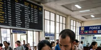 A couple study a map of Cambodia and Myanmar with their passports at a border transport terminal