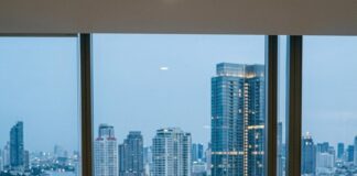 Two property consultants study a scale model in a CBRE office overlooking the Chao Phraya river