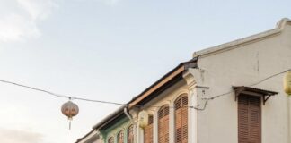 Moving to Penang: A Comprehensive Guide to Your New Life in Malaysia A cyclist passes restored shophouses and a street food cart on a George Town street in Penang