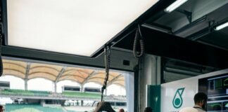 Formula 1 Returns to Sepang: Malaysia Hosts Its First Grand Prix Since 2017 A Mercedes-AMG mechanic works on a Formula One car in the pit garage at Sepang, a race suit hanging beside him