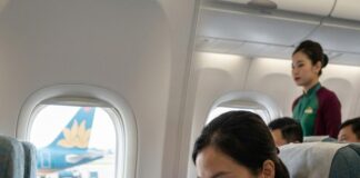 “Celebrating 50 Years of Diplomacy: Vietnam Airlines and Tat Team Up to Elevate Tourism” A passenger reads an inflight brochure aboard a Vietnam Airlines aircraft, another of the airline's jets visible through the window