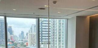 “Thai PM Rallies Tycoons: Can They Save the Economy?” Thai officials and executives meet around a boardroom table overlooking a Bangkok expressway