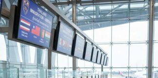 Thailand Visa Reform: Understanding the 60-Day Visa-Free Rollback, 93-Country Exemption, and Impact on Destination Thailand Visa (DTV) Under the Anutin Administration Travellers queue with luggage at Thai immigration desks beneath a screen listing visa-exempt nationalities
