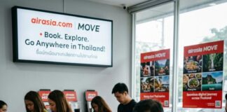 Airasia’s Bold Move: Boosting Thailand Travel Like Never Before! Staff in AirAsia Move uniforms help customers at a Thai travel service counter beneath a promotional screen