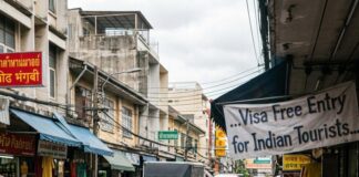 Travel Demand Gets Brighter An Indian tourist changes money at a Bangkok street kiosk beneath a Visa Free Entry for Indian Tourists banner