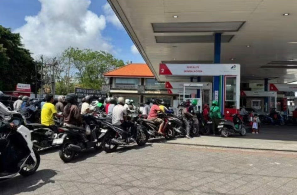 A long line of motorbikes queuing at a petrol station in Bali