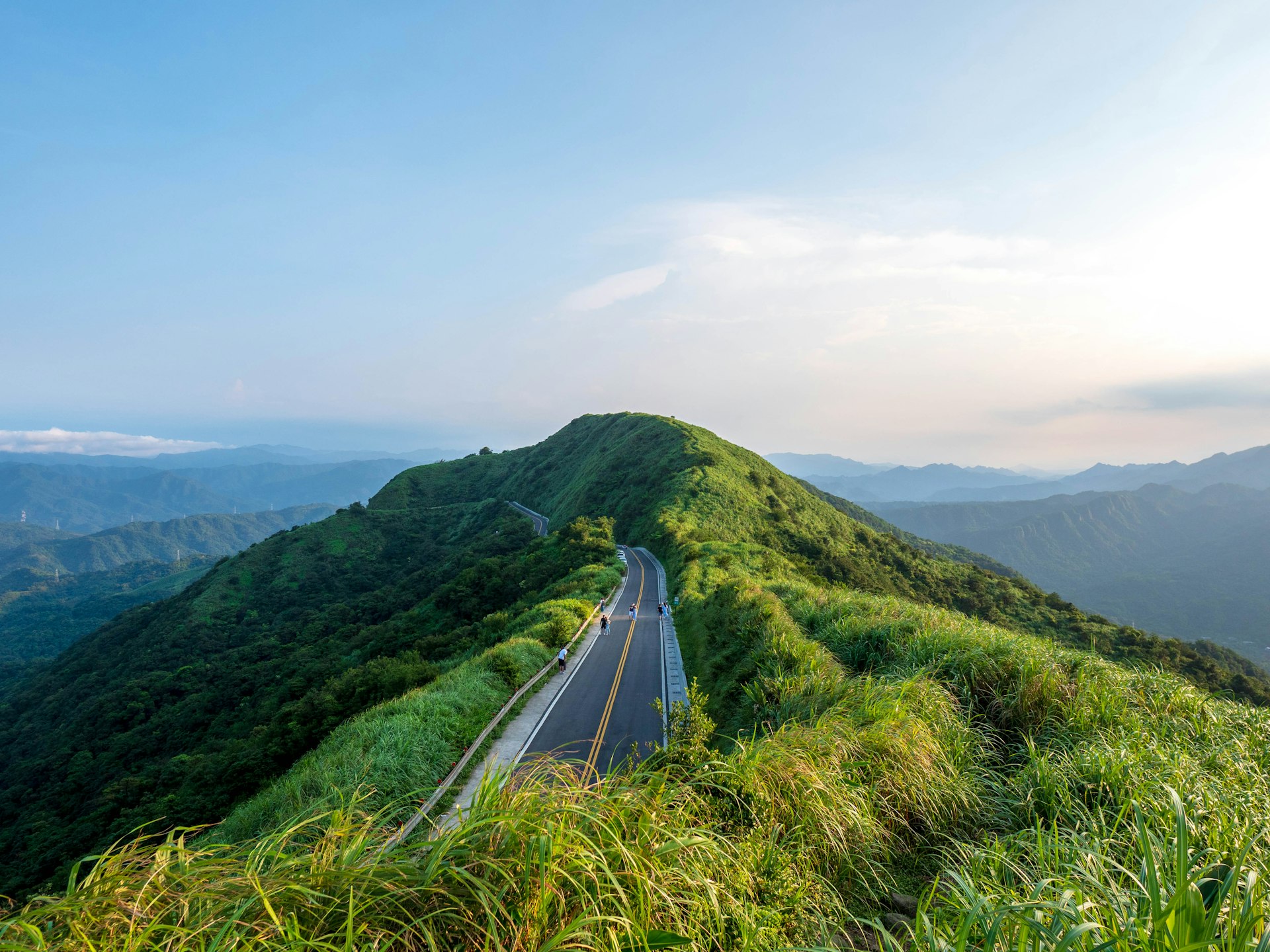 Green fields beneath forested mountains in rural Taiwan