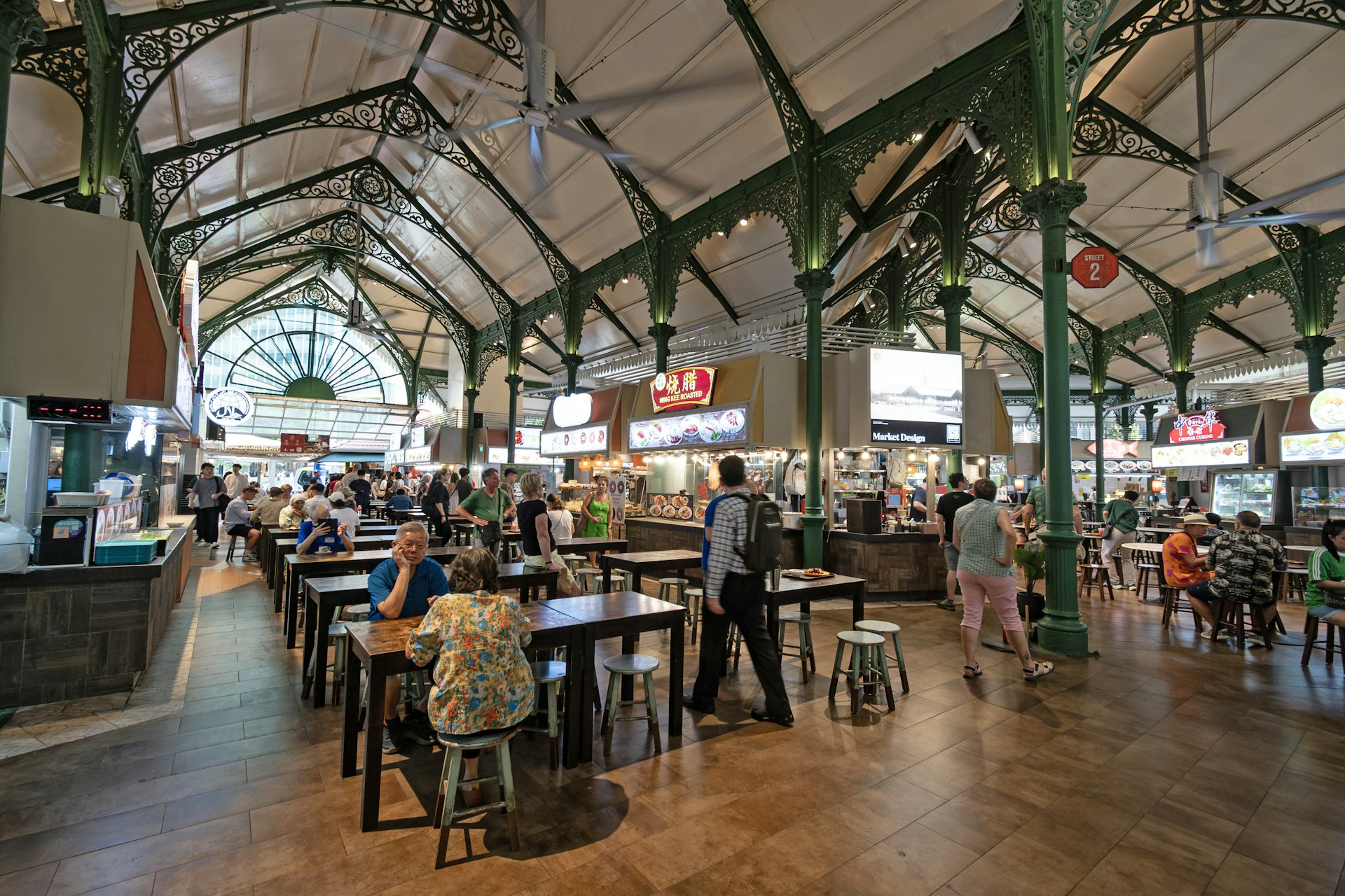 Diners sitting at shared tables inside a Singapore hawker centre