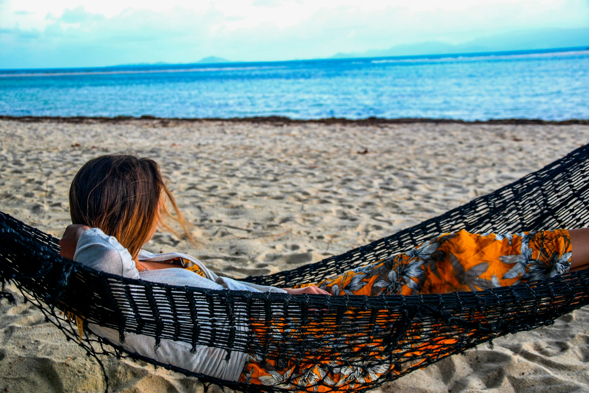 Woman relaxing in a hammock on a tropical beach
